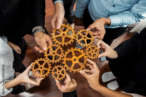 Group of multiracial business people joining gear wheels together as effective unity and productive teamwork concept. Efficient system business team process for solution solving. Meticulous