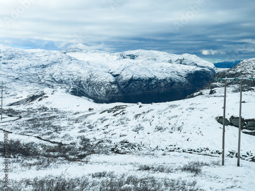 A winter landscape along the Sognefjellsvegen road in Norway, featuring snow-covered mountains and a vast, serene terrain. photo