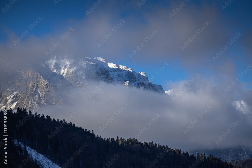 Winter in the Romanian mountains. Beautiful view through the clouds to Bucegi Mountains, next to Busteni, Azuga, Sinaia and Predeal mountain ski resorts. Travel and hike to Romania.