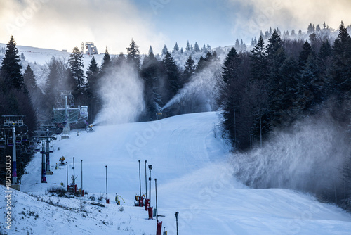 Obraz na płótnie Ski resort. Empty ski slopes in the early morning with snow making machines powered on to create more snow. Snow cannon at winter sports resorts. w salonie