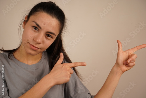 The fingers are aligned in a way that seems to indicate a direction. A woman points with both index fingers as if aiming. This gesture symbolizes healing through intention and mindfulness. photo