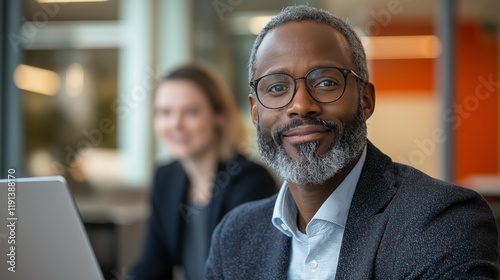 A confident businessman with glasses smiling in a modern office, radiating professionalism and leadership photo