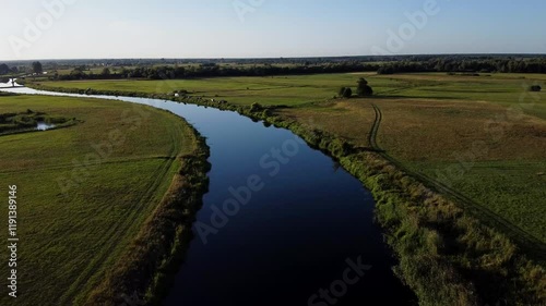  View of a Beautiful  River at Sunset Surrounded by Green Fields Drone Aerial 4K Slow Motion