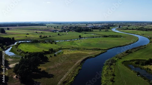  View of a Beautiful  River at Sunset Surrounded by Green Fields Drone Aerial 4K Slow Motion