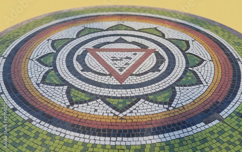 Circular mosaic tile artwork with a central triangle and lotus design. photo