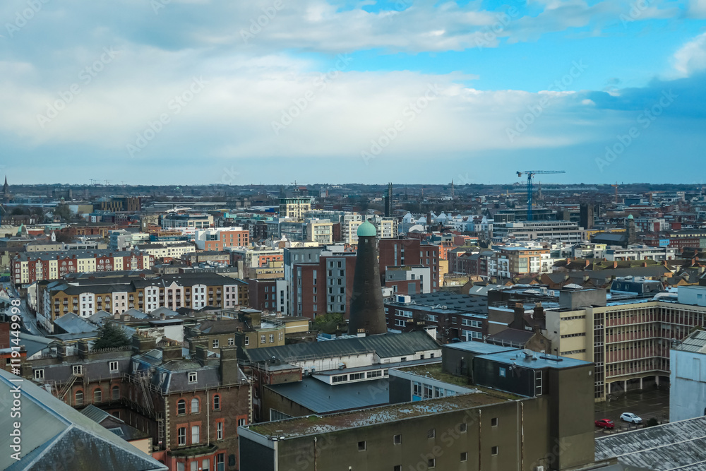 Fototapeta premium Panoramic view of Dublin from the Gravitiy bar in Guinness Storehouse in Ireland. Dense urban environment with a variety of buildings. Fermentation plant for the Guinness brewery. Aerial perspective