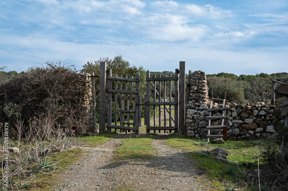 Rustic wooden gate with dry stone wall in a rural countryside Rustic wooden gate with dry stone wall in a rural countryside