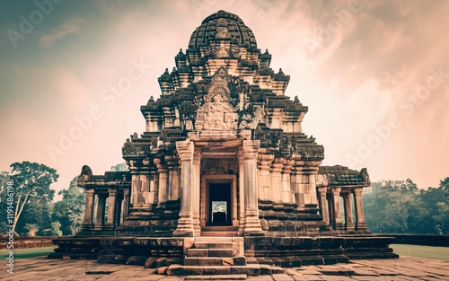 Ancient stone temple at sunrise, intricate carvings, tiered roof, entrance. photo