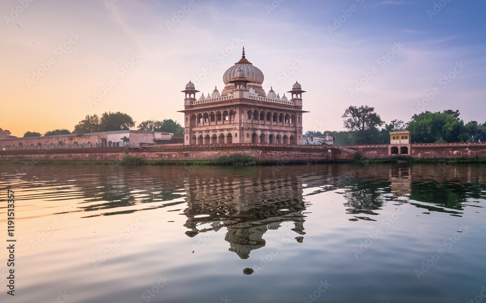 Fototapeta premium Sunrise reflection of a historical building on calm water.