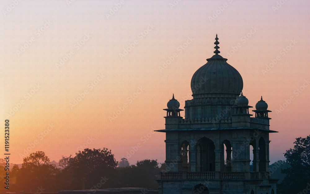 Obraz premium Sunrise silhouette of an ornate stone dome structure.
