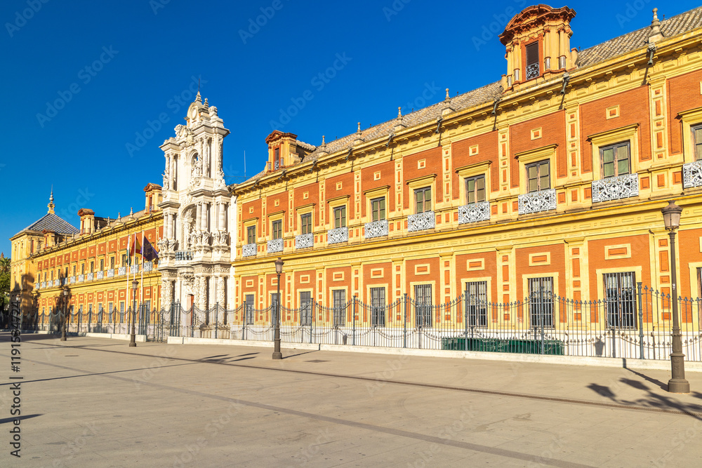 Obraz premium The Palace of San Telmo in Seville town, capital of Andalusia in Spain. Grand historical building on a sunny day. Elegant architecture and a wide plaza.