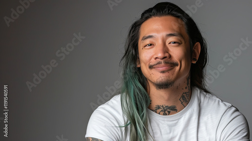Man with long hair and tattoos on his neck and face is smiling