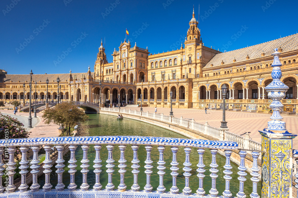 Fototapeta premium The Plaza de Espana, Spain square in Seville town, Andalusia, Spain. Spanish plaza with ornate architecture and a tranquil canal. A picturesque scene perfect for travel or tourism.