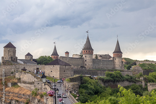 Historic castle landscape under a dramatic cloudy sky with green surroundings photo