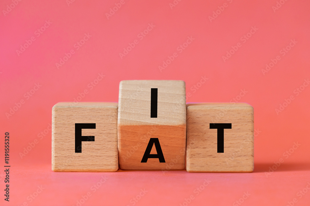 Hand is turning wooden block and changes the word FAT to FIT. Conceptual words. Changing habits. Healthy lifestyle. Losing weight. Copy space