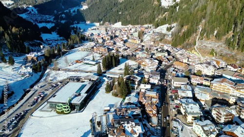 Canazei, a picturesque alpine town in the Dolomites, offers stunning winter landscapes and world-class ski facilities. Surrounded by snow-capped peaks and captured by drone photo