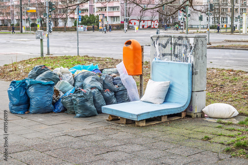 Illegale Müllentsorgung mit vielen Müllsäcken und Sperrmüll auf einer Straße in der Großstadt