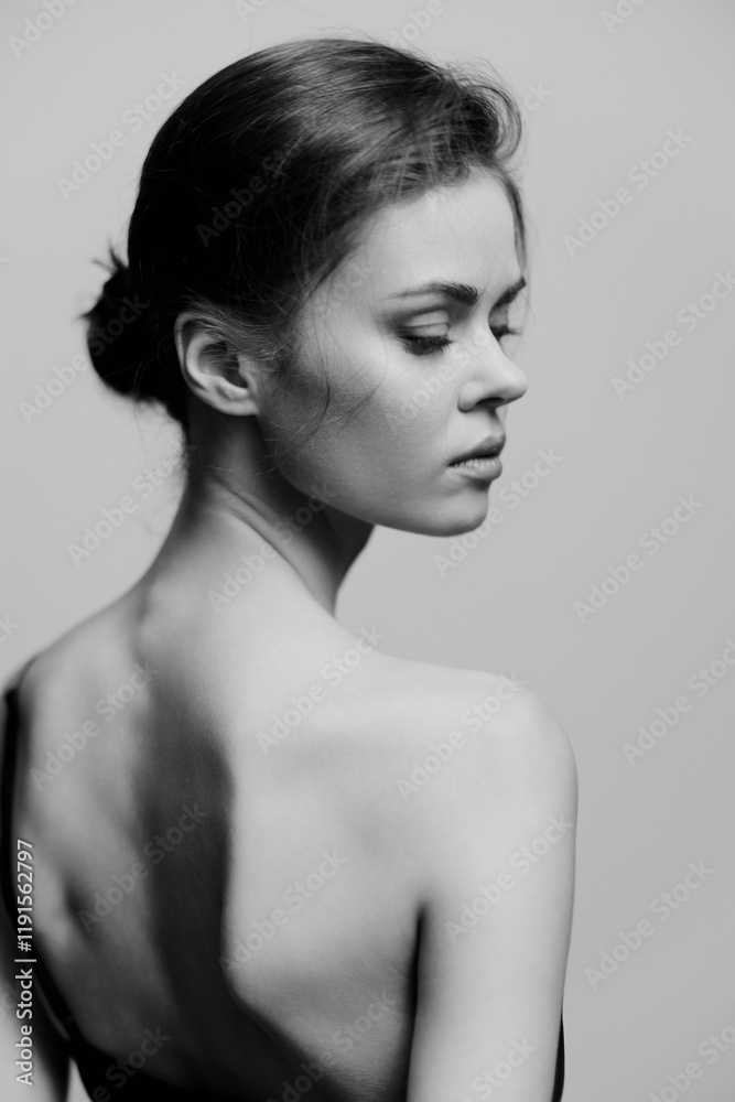 Elegant woman with a smooth back, captured in a black and white portrait, exuding grace and introspection against a soft, minimalistic background. Elegant woman with a smooth back, captured in a black and white portrait, exuding grace and introspection against a soft, minimalistic background.