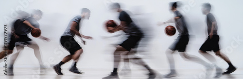 Amidst blurry motion, several basketball players are captured dribbling and moving across a gym court. Their focused expressions and concentrated movements highlight the energy of the game.