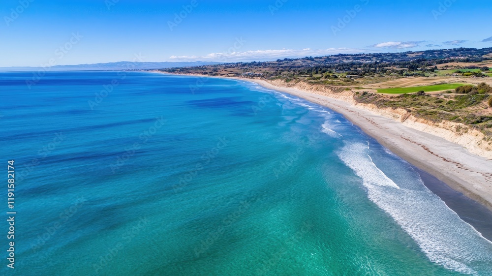 Coastal landscape with rolling waves, clear sky, and sandy shore Coastal landscape with rolling waves, clear sky, and sandy shore