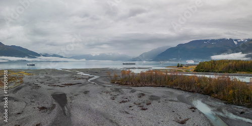 Panoramic view of scenic Port Valdez landscape with low lying clouds.