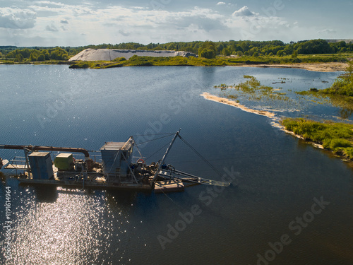 Suction dredger vessel works drawing up bottom mud on river