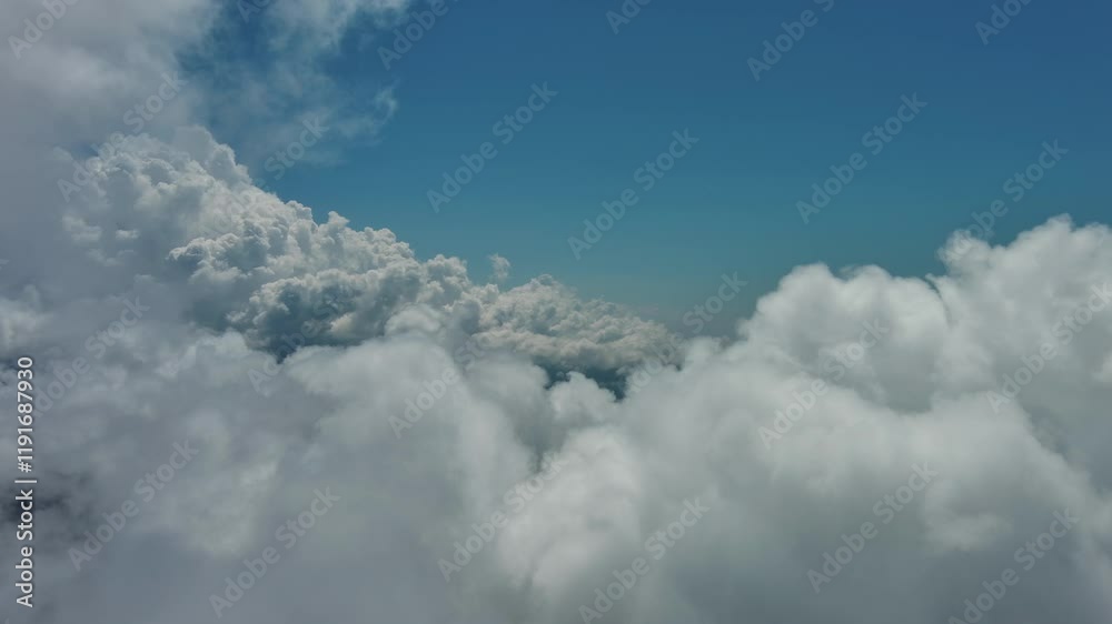 Flying through beautiful white fluffy clouds in blue sky. Airplane travel background, 4k