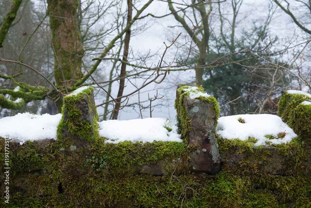 Stone wall with lake in rear of shot and snow on the wall. Stone wall with lake in rear of shot and snow on the wall.