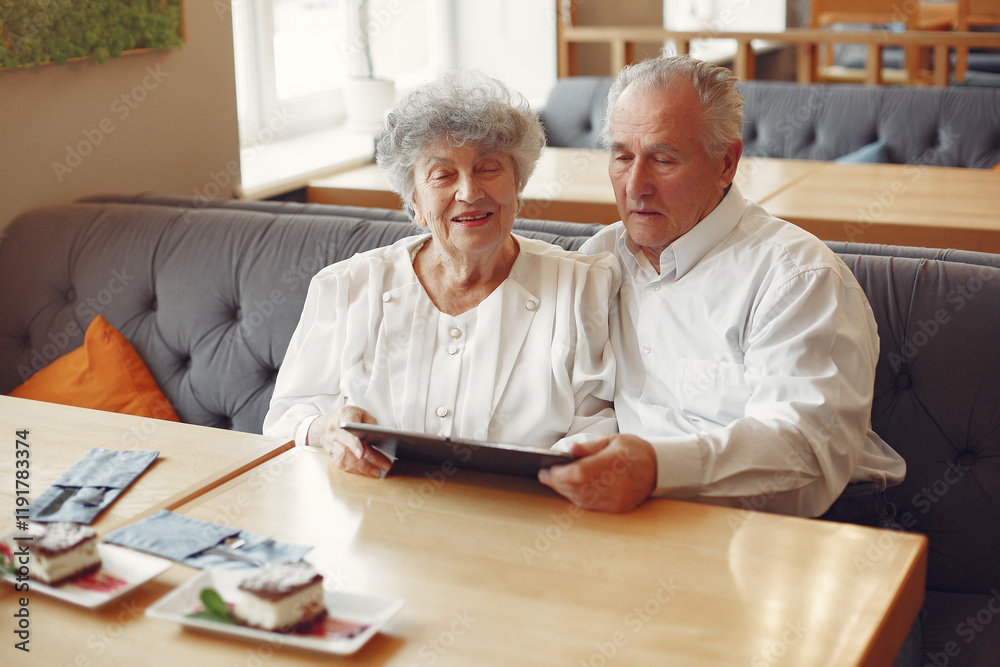 Elegant old couple in a cafe using a tablet Elegant old couple in a cafe using a tablet