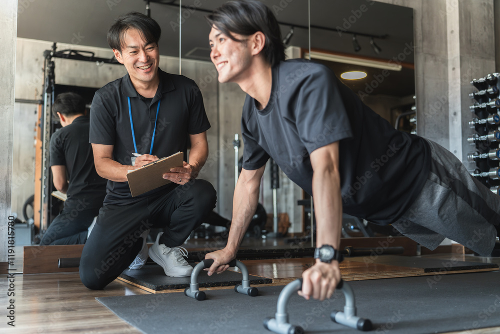 Obraz premium スポーツジムでパーソナルトレーニングを受ける若いアジア人男性 