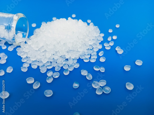 PP plastic pellets, virgin polypropylene polymer plastic granules poured into blue background, for product catalog design of industrial plastic manufacturing company profile photo