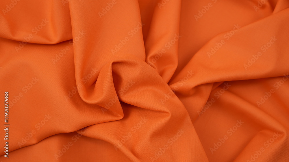 Obraz premium Close-up of orange cotton fabric showing a detailed woven texture, soft natural fibers, and a smooth textile surface perfect for design or background use.