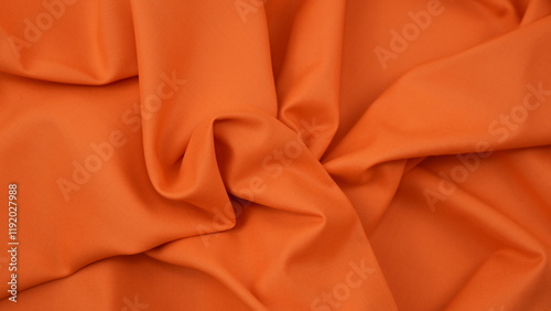 Close-up of orange cotton fabric showing a detailed woven texture, soft natural fibers, and a smooth textile surface perfect for design or background use.