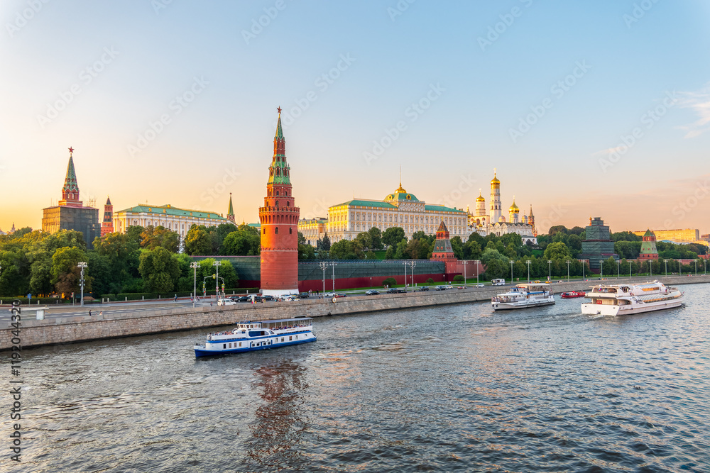 Obraz premium View of Kremlin with Vodovzvodnaya tower, Grand Kremlin Palace from repaired Bolshoy Kamenny Bridge in Moscow city on sunny summer day. Cruise ship sails on the Moscow river