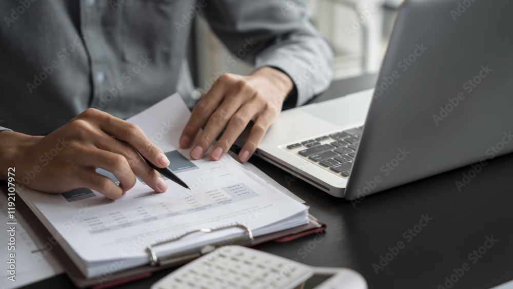 Asian business man holding paper document calculating tax insurance managing budget Asian business man holding paper document calculating tax insurance managing budget