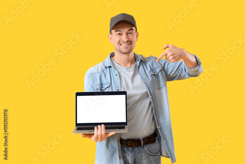 Man with laptop on yellow b...