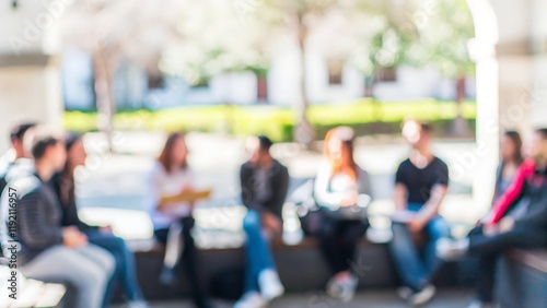 Outdoor Academic Discussion – A blurred image of students sitting outdoors, engaging in an academic discussion.
