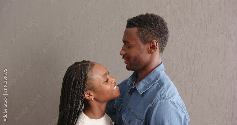 Smiling african american couple embracing and looking at each other ...