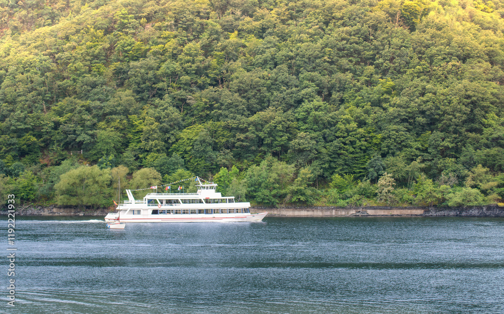 Excursion Ship on a lake in the mountains with a green hill in the background Excursion Ship on a lake in the mountains with a green hill in the background