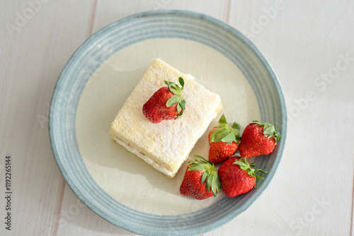 Japanese shortcake with strawberries on top is placed on a white wooden floor photo