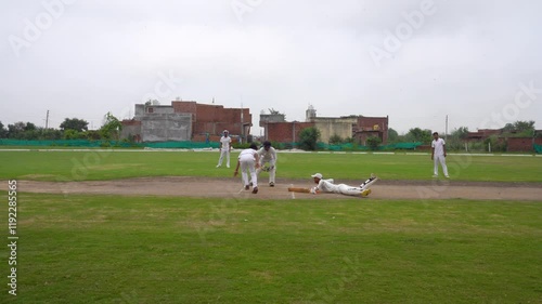 Batsman hitting the ball, A Wicket Keeper prepares to run out a Batsman during a match
