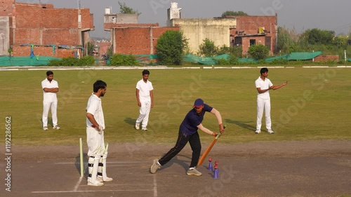 The cricket coach provides instructions to the batsman during a practice session