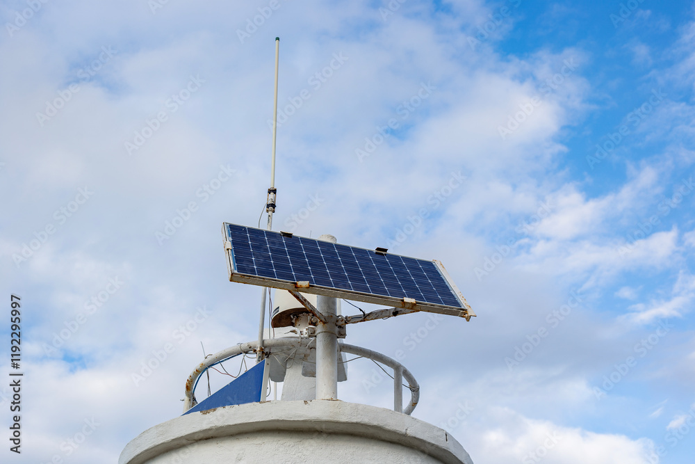 solar panel on the lighthouse with blue sky and white clouds background close-up solar panel on the lighthouse with blue sky and white clouds background close-up