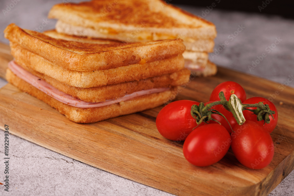 Fresh Ham and Cheese Sandwich with Cherry Tomatoes on a Dark Cutting Board Fresh Ham and Cheese Sandwich with Cherry Tomatoes on a Dark Cutting Board