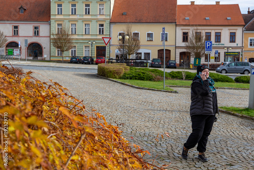 Obraz na płótnie A woman walking through the city on an autumn day. w salonie