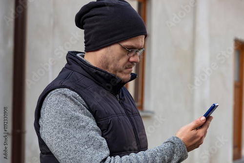 Obraz na płótnie A man with a smartphone walking through an autumn city. w salonie