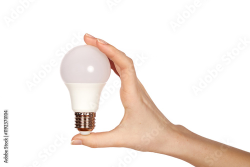 Female hand holding LED lamp with metal base on white background.