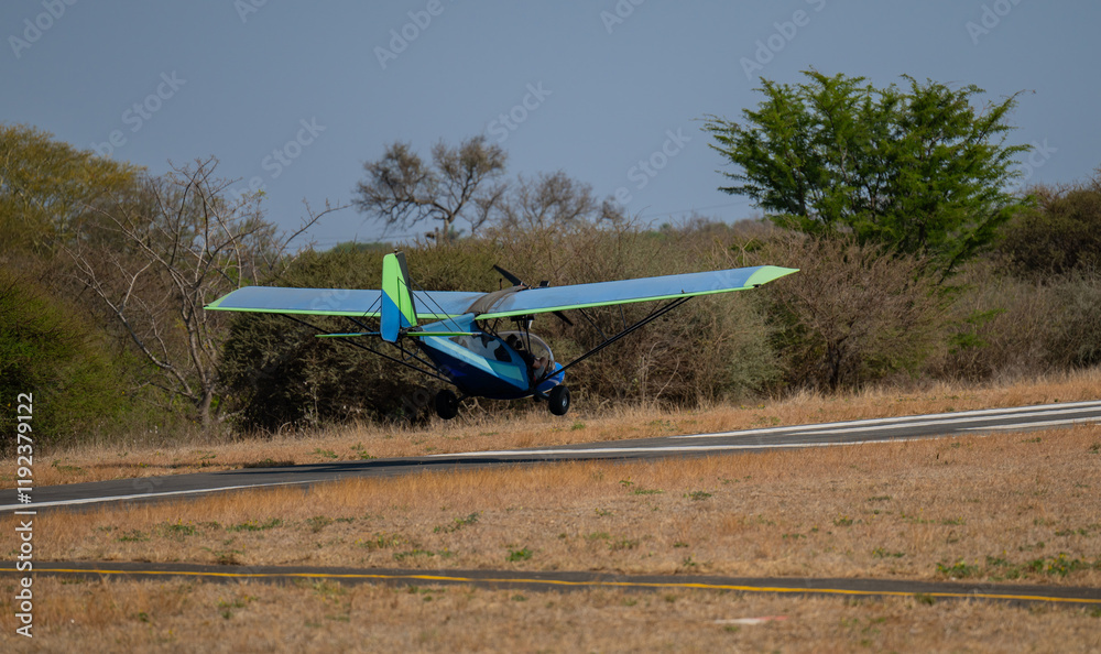 Ultralight aircraft or Microlight aircraft taking off on the runway in Hoedspruit South Africa