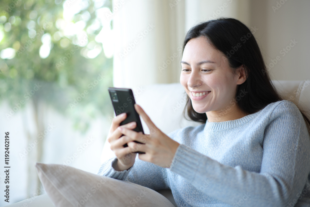 Happy asian woman using smart phone at home Happy asian woman using smart phone at home