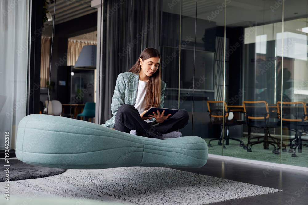 Business woman sitting on sofa and using tablet PC at office Business woman sitting on sofa and using tablet PC at office